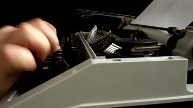 Adam eski bir daktiloyla daktilo yazıyor..