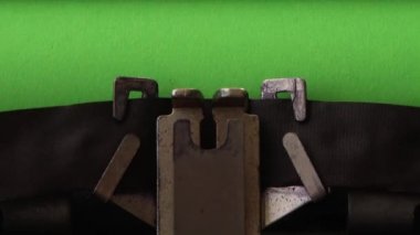 Yeşil sayfada retro daktiloyla daktilo yazıyorum. Kromakey.