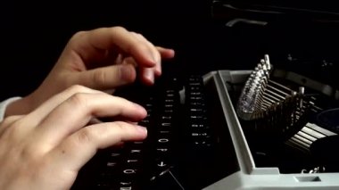 Kız retro bir daktiloyla daktilo yazıyor..