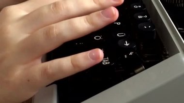 Kız retro bir daktiloyla daktilo yazıyor..