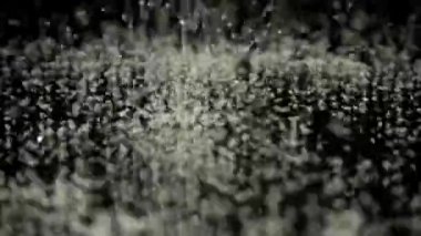 Siyah ayna arka planına düşen şeker taneleri. Yavaş çekim.