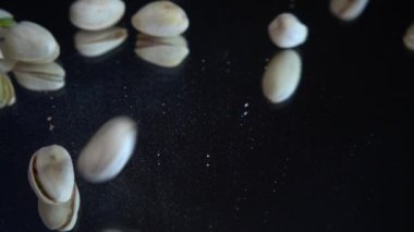 Fıstık ezmesi siyah bir ayna yüzeyine düşer. Yavaş çekim.