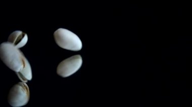 Fıstık ezmesi siyah bir ayna yüzeyine düşer. Yavaş çekim.