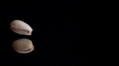 Fıstık ezmesi siyah bir ayna yüzeyine düşer. Yavaş çekim.