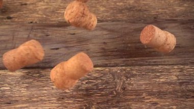 Şampanyanın şarap mantarları eski bir tahtanın üzerine düşüyor. Yavaş çekim.