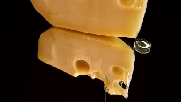 Gotas Miel Fluyen Desde Queso Sobre Fondo Negro Espejado — Vídeos de Stock