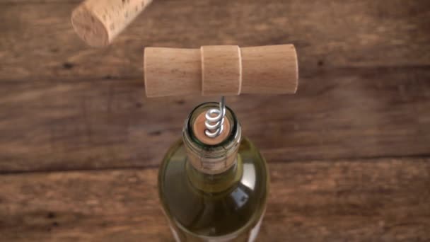 ワインのコルク栓は ワインのボトルに詰まったコルク栓ねじの背景に古い木製の板に落ちる スローモーション — ストック動画