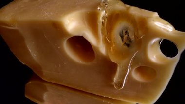 Aynalı siyah arka planda peynirden bal damlaları akıyor..