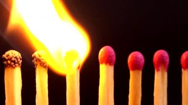 Siyah arkaplanda kibrit yakılıyor.