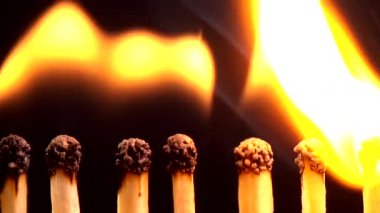 Siyah arkaplanda kibrit yakılıyor.