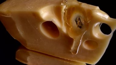 Aynalı siyah arka planda peynirden bal damlaları akıyor..