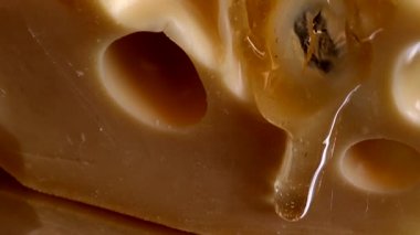 Aynalı siyah arka planda peynirden bal damlaları akıyor..