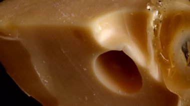 Aynalı siyah arka planda peynirden bal damlaları akıyor..