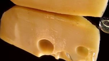 Aynalı siyah arka planda peynirden bal damlaları akıyor..
