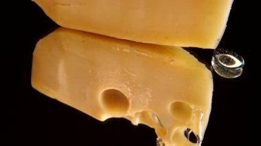 Aynalı siyah arka planda peynirden bal damlaları akıyor..