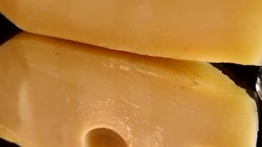 Aynalı siyah arka planda peynirden bal damlaları akıyor..