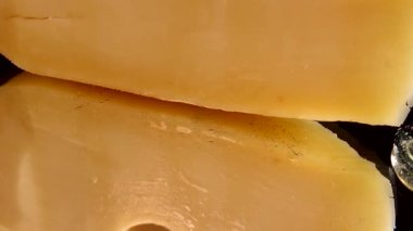 Aynalı siyah arka planda peynirden bal damlaları akıyor..