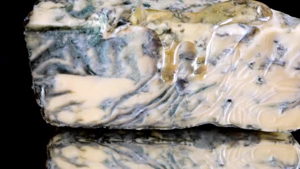 Dorblu Peynirinden Akmakta Olan Bal Damlaları Aynalı Siyah Arka Planda — Stok video