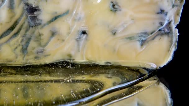 鏡のような黒の背景にドーブルチーズから流れる蜂蜜の滴 — ストック動画