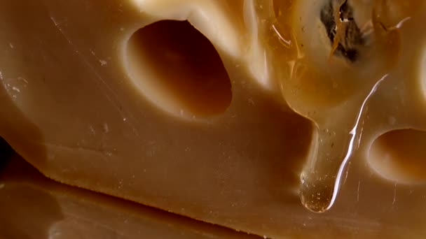 Tropfen Honig Fließen Vom Käse Auf Einem Verspiegelten Schwarzen Hintergrund — Stockvideo