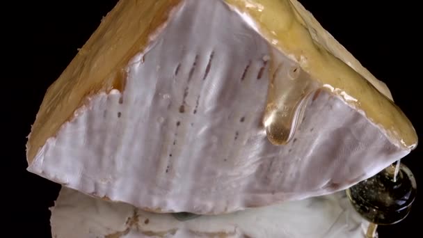 Druppeltjes Honing Van Brie Cheese Een Gespiegelde Zwarte Achtergrond — Stockvideo