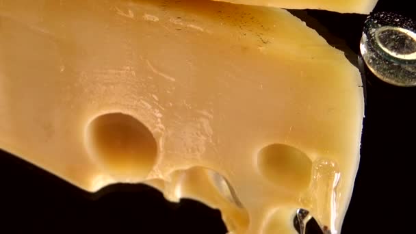 Tropfen Honig Fließen Vom Käse Auf Einem Verspiegelten Schwarzen Hintergrund — Stockvideo