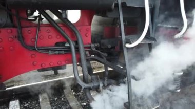 A retro steam locomotive prepares to leave the station.