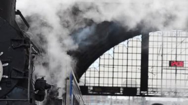 A retro steam locomotive prepares to leave the station.