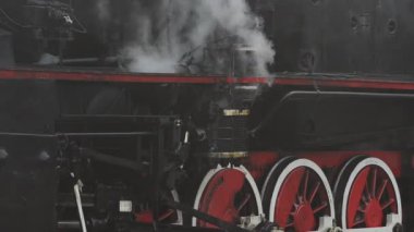 A retro steam locomotive prepares to leave the station.