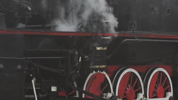A retro steam locomotive prepares to leave the station.