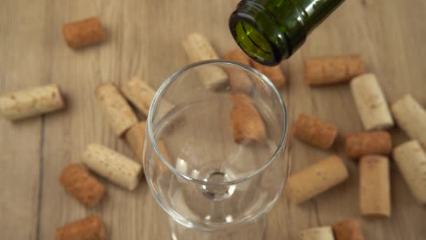 ワインはワインコルクを背景にグラスに注がれます — ストック動画