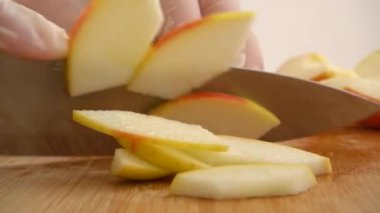 Aşçı kesme tahtasında bir elma keser..