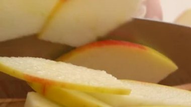 Aşçı kesme tahtasında bir elma keser..