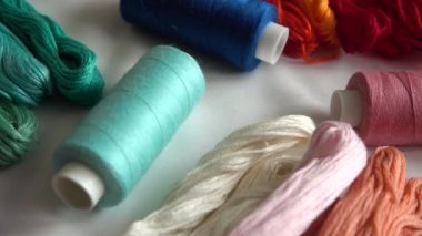 Beyaz arkaplanda izole edilmiş renkli küf ipliklerinin ve çok renkli makaraların üst görünümü.