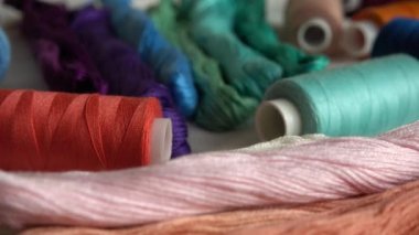 Beyaz arkaplanda izole edilmiş renkli küf ipliklerinin ve çok renkli makaraların üst görünümü.