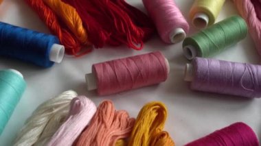 Beyaz arkaplanda izole edilmiş renkli küf ipliklerinin ve çok renkli makaraların üst görünümü.