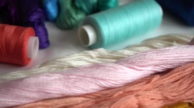 Beyaz arkaplanda izole edilmiş renkli küf ipliklerinin ve çok renkli makaraların üst görünümü.