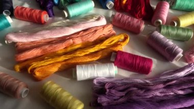 Beyaz arkaplanda izole edilmiş renkli küf ipliklerinin ve çok renkli makaraların üst görünümü.