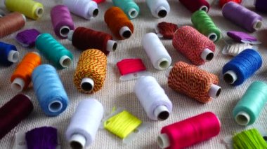 Renkli küf ipliklerinin ve çuval bezi arka planında izole edilmiş çok renkli makaraların üst görünümü.