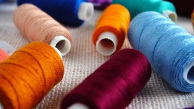 Renkli küf ipliklerinin ve çuval bezi arka planında izole edilmiş çok renkli makaraların üst görünümü.