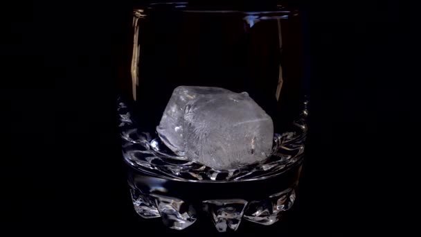 Verter Whisky Vaso Con Hielo Sobre Fondo Negro Aislado Movimiento — Vídeos de Stock