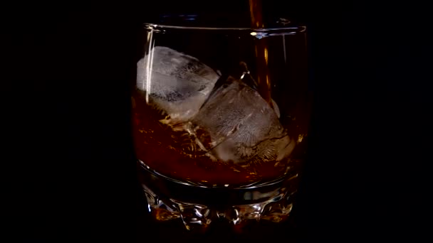 Nalít Whisky Sklenice Ledem Izolovaném Černém Pozadí Zpomalený Pohyb — Stock video