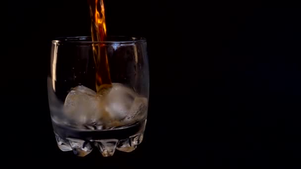Zole Edilmiş Siyah Arka Planda Buzlu Bir Bardağa Viski Dökmek — Stok video