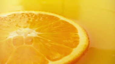 Meyve suyunda bir dilim portakal, düşen bir damla. Yavaş çekim.