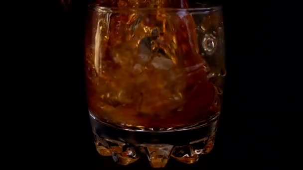 Versare Whisky Bicchiere Con Ghiaccio Uno Sfondo Nero Isolato Rallentatore — Video Stock