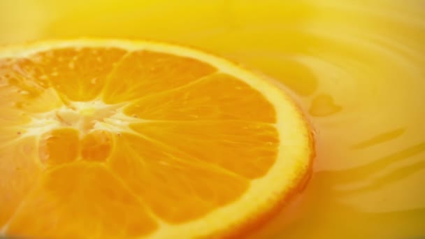 Μια Φέτα Πορτοκάλι Επιπλέει Χυμό Μια Σταγόνα Που Πέφτει Αργή — Αρχείο Βίντεο
