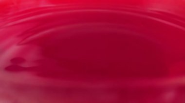 Sicilya portakallarının suyunun yüzeyine bir damla su düşer. Yavaş çekim.