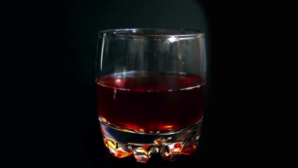Ijsblokjes Een Whiskyglas Een Geïsoleerde Zwarte Achtergrond Langzame Beweging — Stockvideo