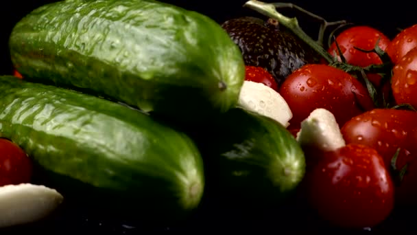 Tomates Cherry Pepinos Ajo Aguacate Cebolla Roja Sobre Fondo Negro — Vídeos de Stock