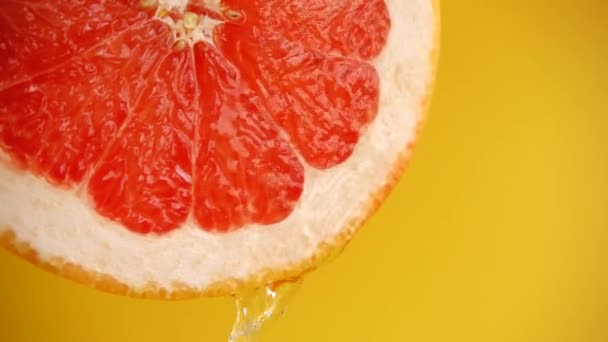 Agua Desciende Una Rodaja Pomelo Sobre Fondo Naranja Movimiento Lento — Vídeos de Stock